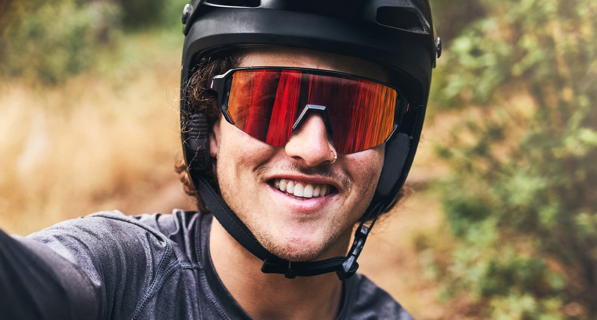 imagine de aproape a unei persoane care poartă cască de bicicletă și ochelari de soare